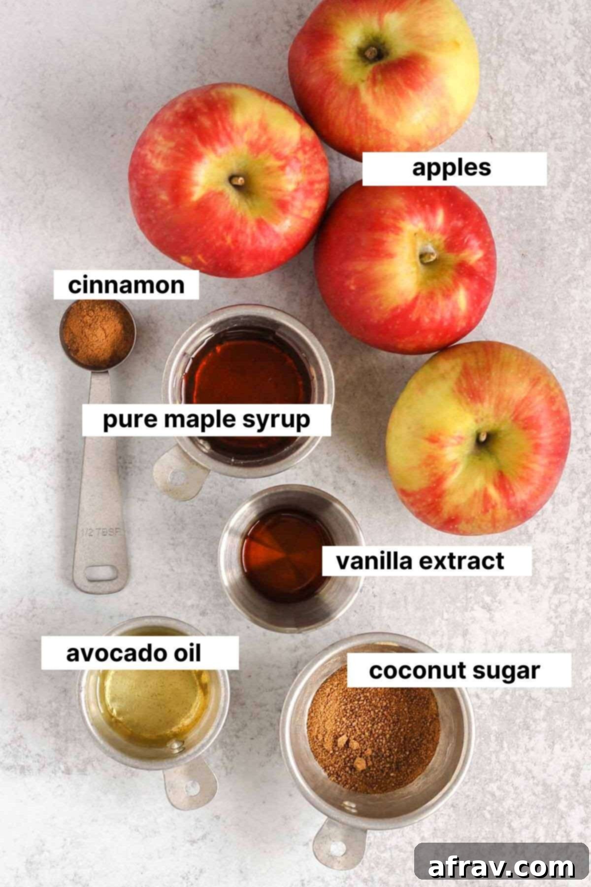 Labeled ingredients for air fryer apples: fresh apples, cinnamon, maple syrup, coconut sugar, avocado oil, and vanilla extract.