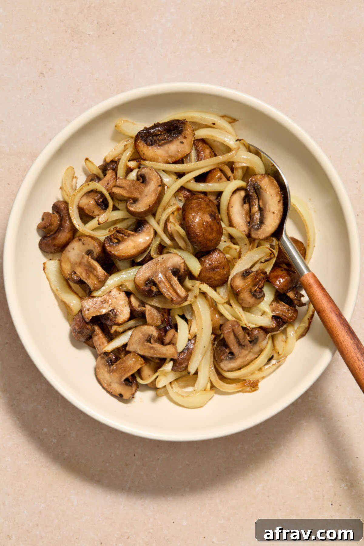 Crispy Air Fryer Mushrooms and Onions 2 Mushrooms and onions served in a bowl with a spoon.