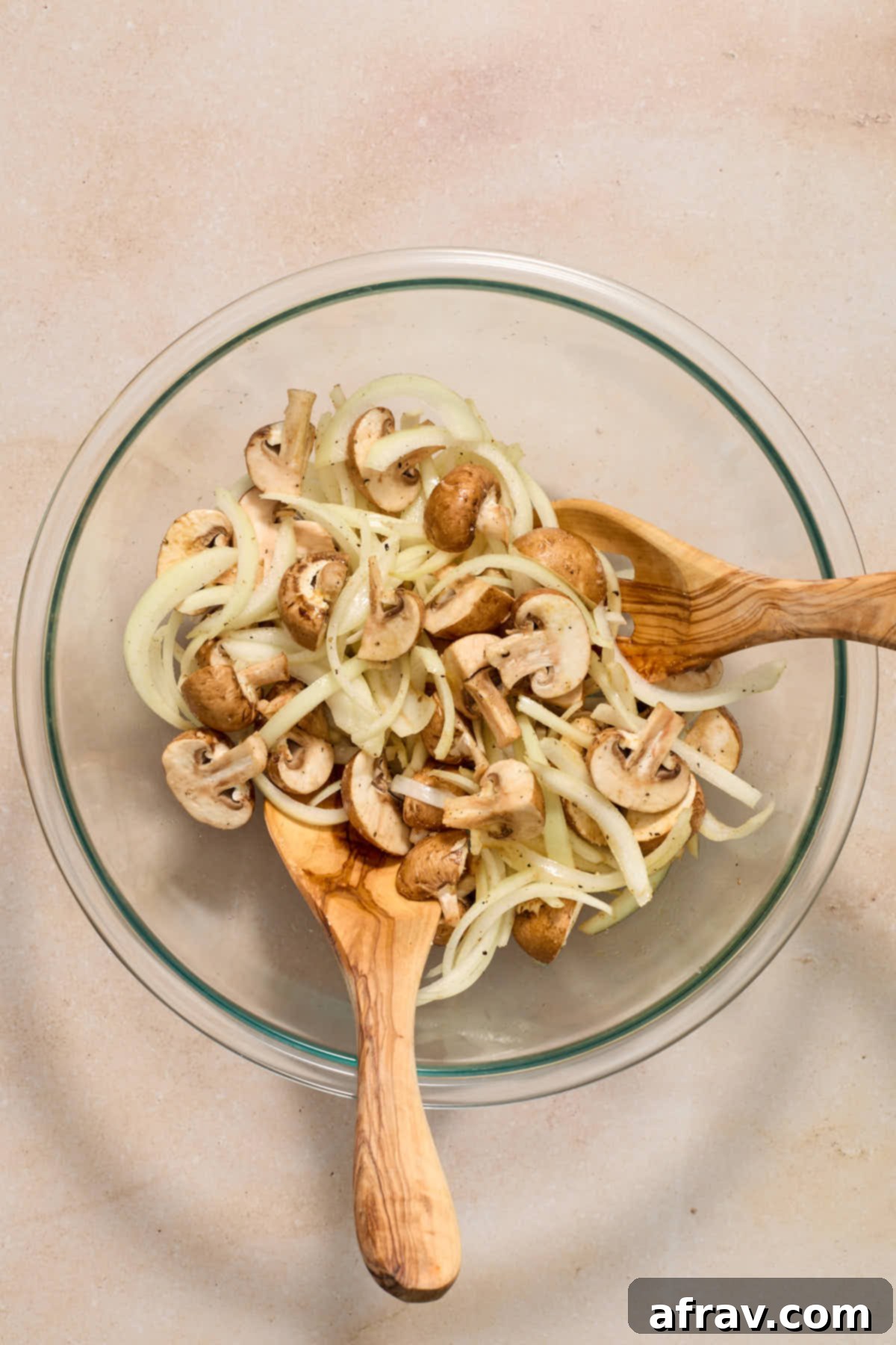 Crispy Air Fryer Mushrooms and Onions 5 Sliced onions and chopped mushrooms in a bowl and tossed together with seasonings.