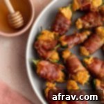 Crispy Air Fryer Dairy Free Jalapeno Poppers 2 Air fryer jalapeño poppers arranged on a plate next to some honey.