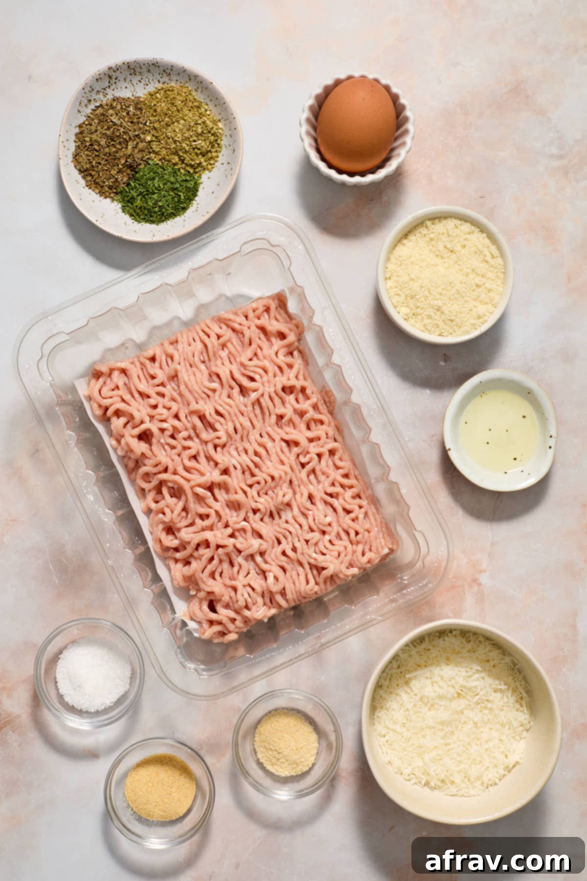 Ingredients to make air fryer chicken meatballs arranged individually on a work surface.