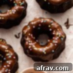 Up close overhead view of mini chocolate bundt cakes topped with glaze and sprinkles.
