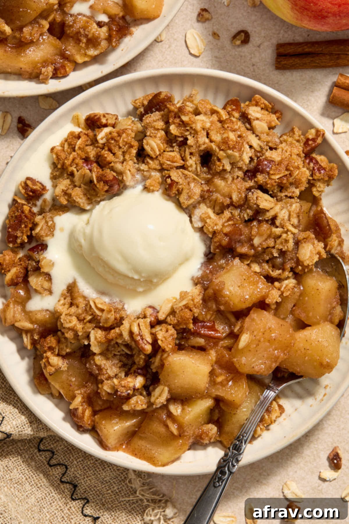 Gluten-Free Almond Flour Apple Pecan Crisp 11 Serving of apple crisp on a plate with melted ice cream on top, ready for indulgence.