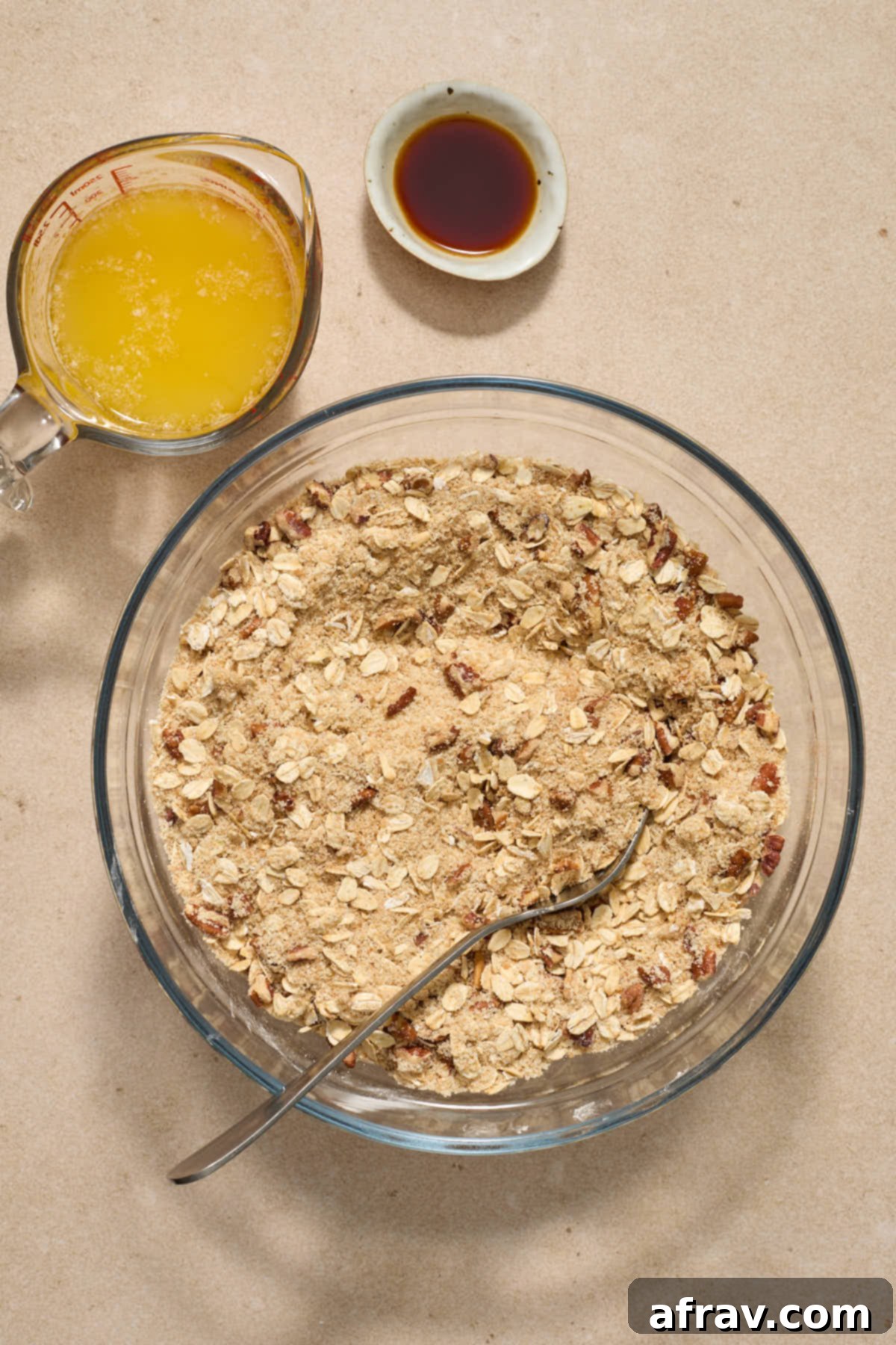 Gluten-Free Almond Flour Apple Pecan Crisp 4 Dry crisp ingredients stirred together in a glass bowl with melted butter and vanilla on the side.