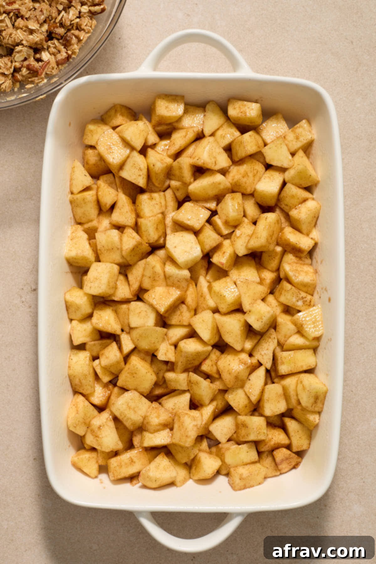 Gluten-Free Almond Flour Apple Pecan Crisp 7 Apple filling spread out evenly in a white baking dish.