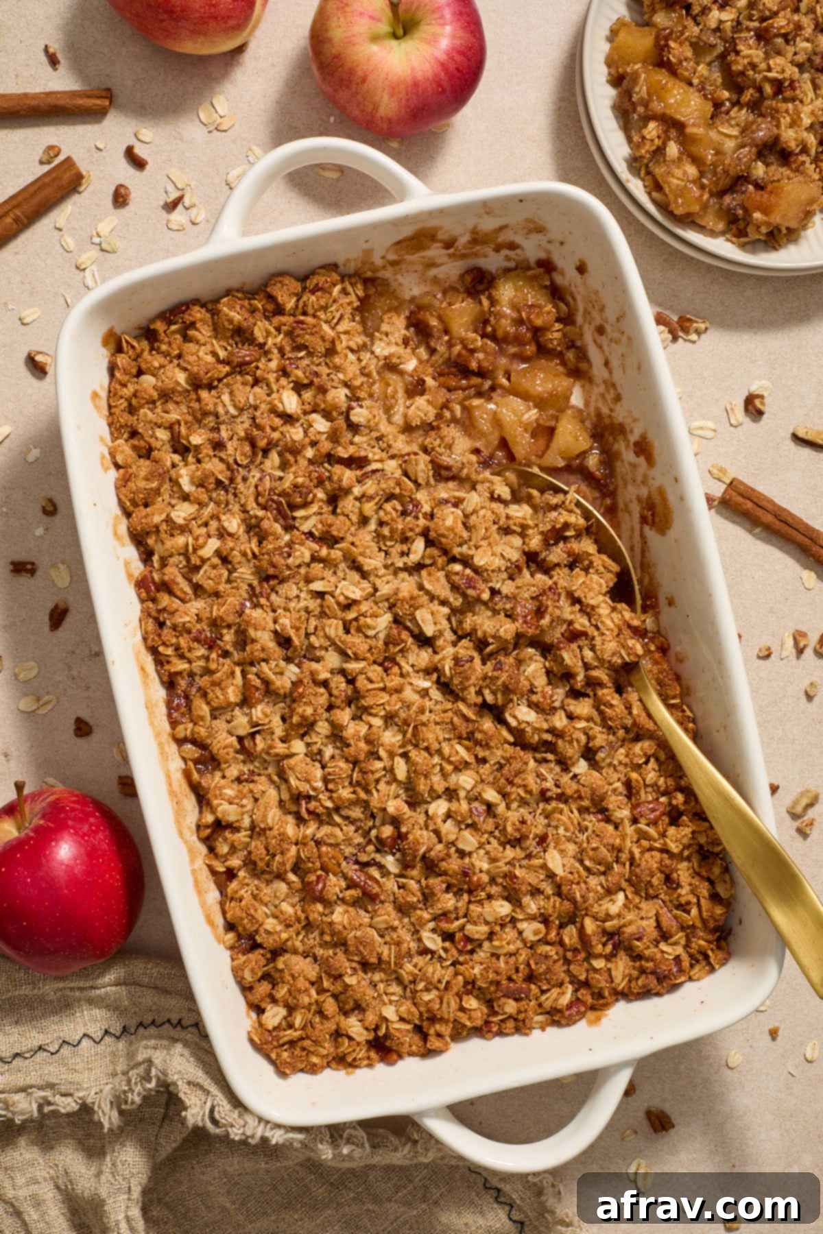 Gluten-Free Almond Flour Apple Pecan Crisp 10 Apple crisp in baking dish with a serving spoon, and a single portion scooped onto a plate.