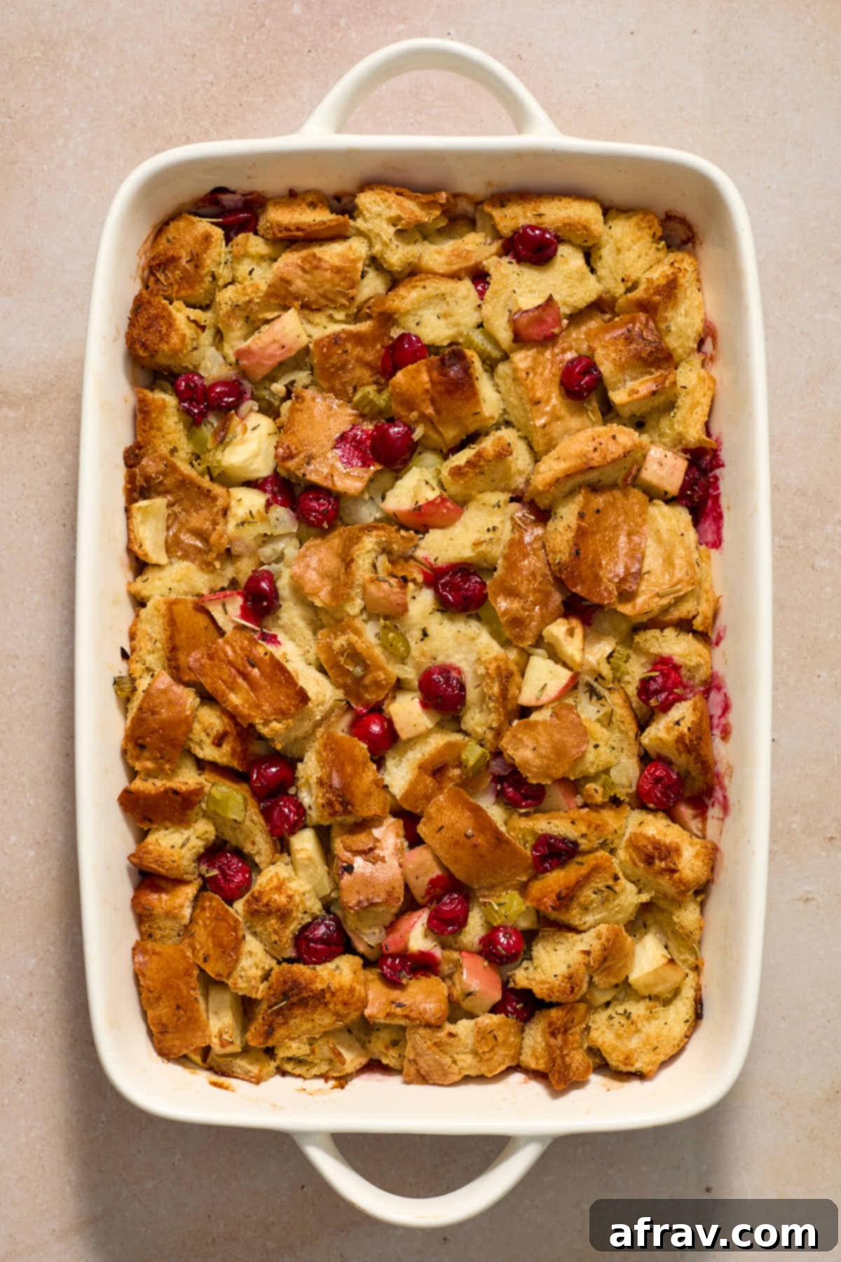 Festive Apple Cranberry Stuffing 11 Baked stuffing in a white baking dish.