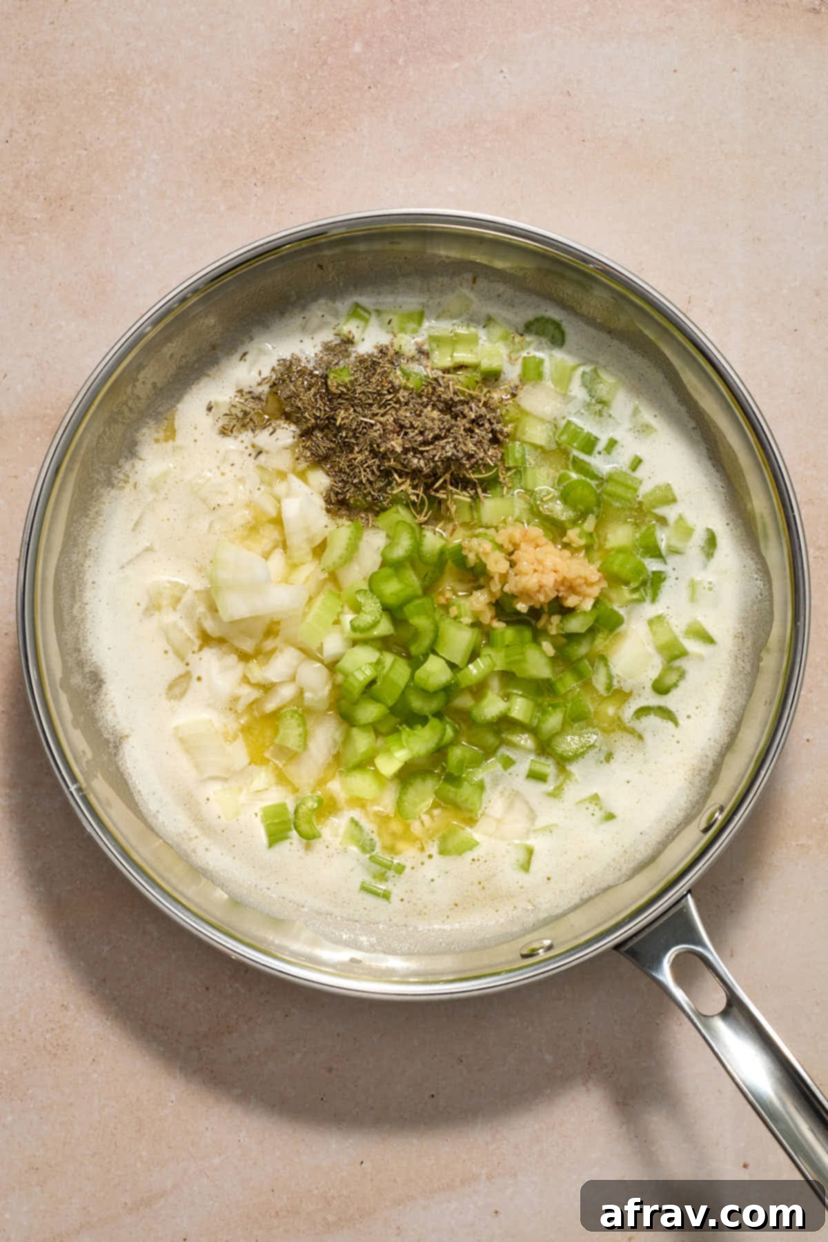 Festive Apple Cranberry Stuffing 5 Celery, onion, garlic and herbs added to melted butter in a skillet.