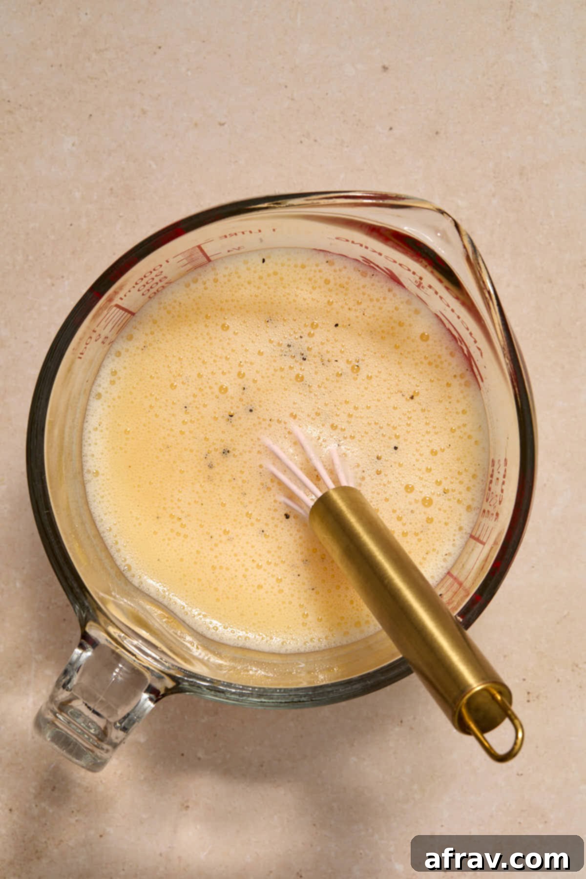 Festive Apple Cranberry Stuffing 7 Eggs, broth, salt and pepper whisked together in a glass measuring cup.