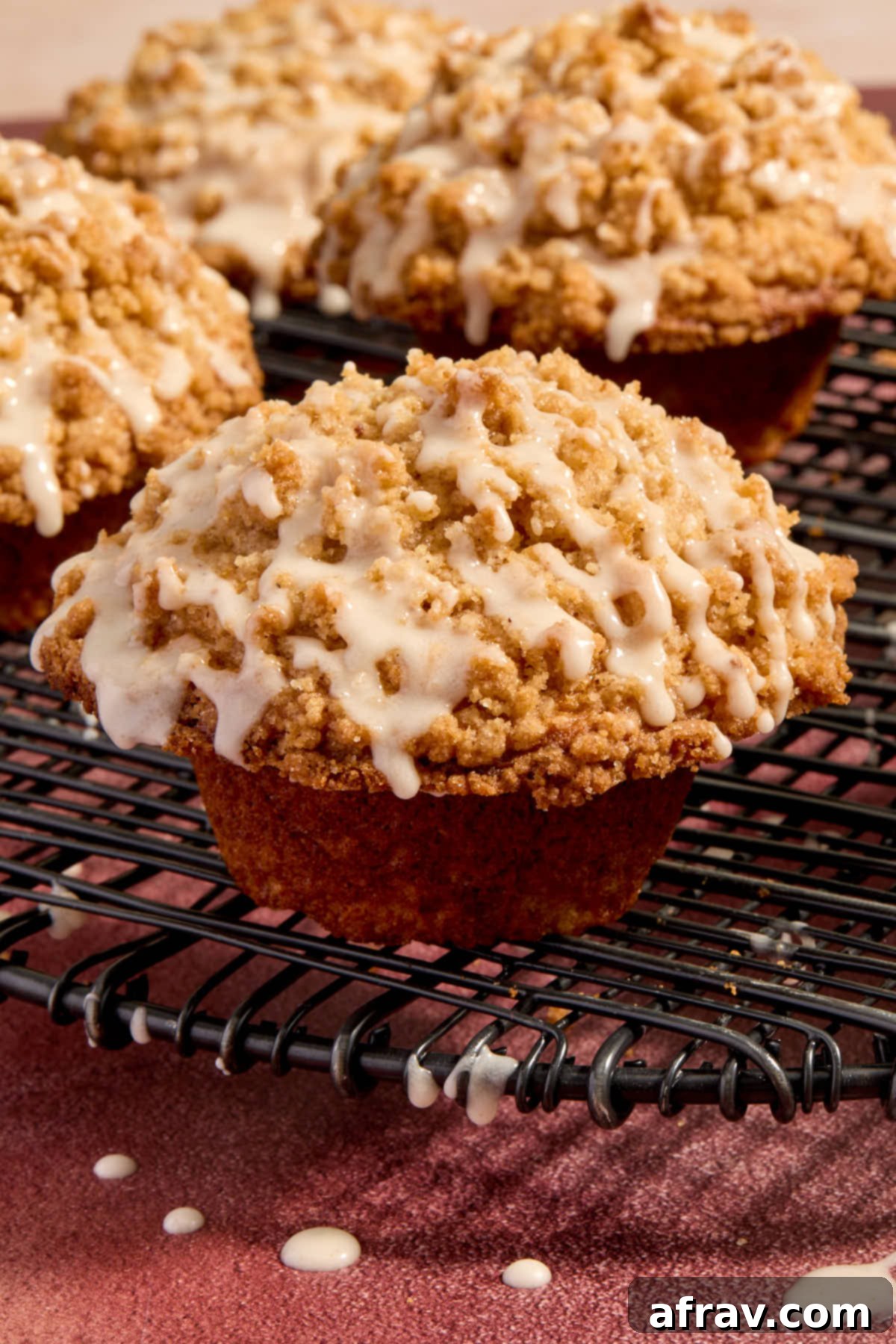 Close up side view of an eggnog muffin with streusel and eggnog glaze on top.