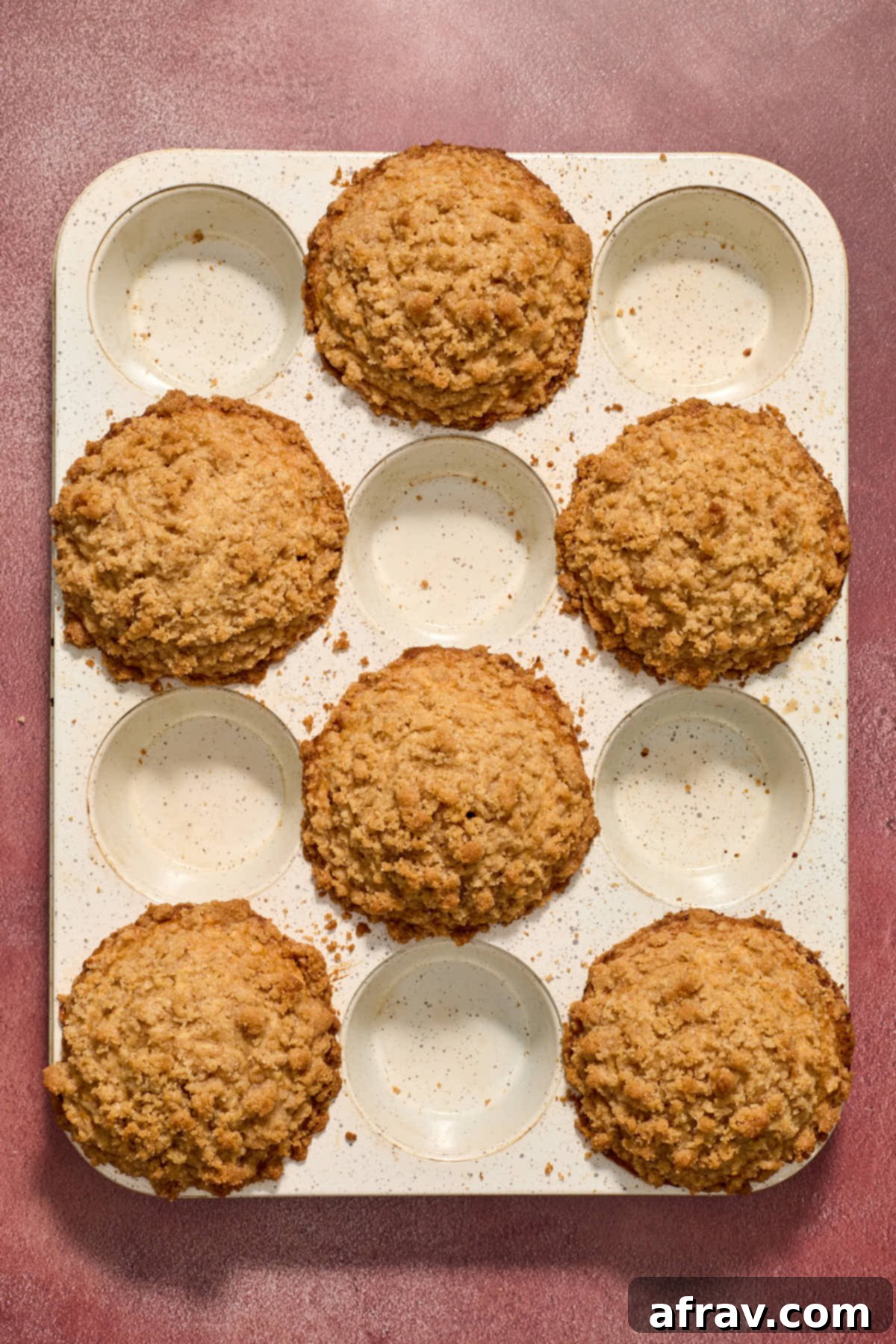 Baked muffins in a white muffin tin.