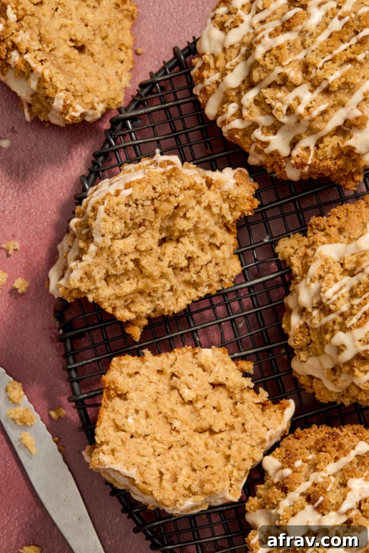 Overhead shot of eggnog muffins on a wire rack with one cut in half.