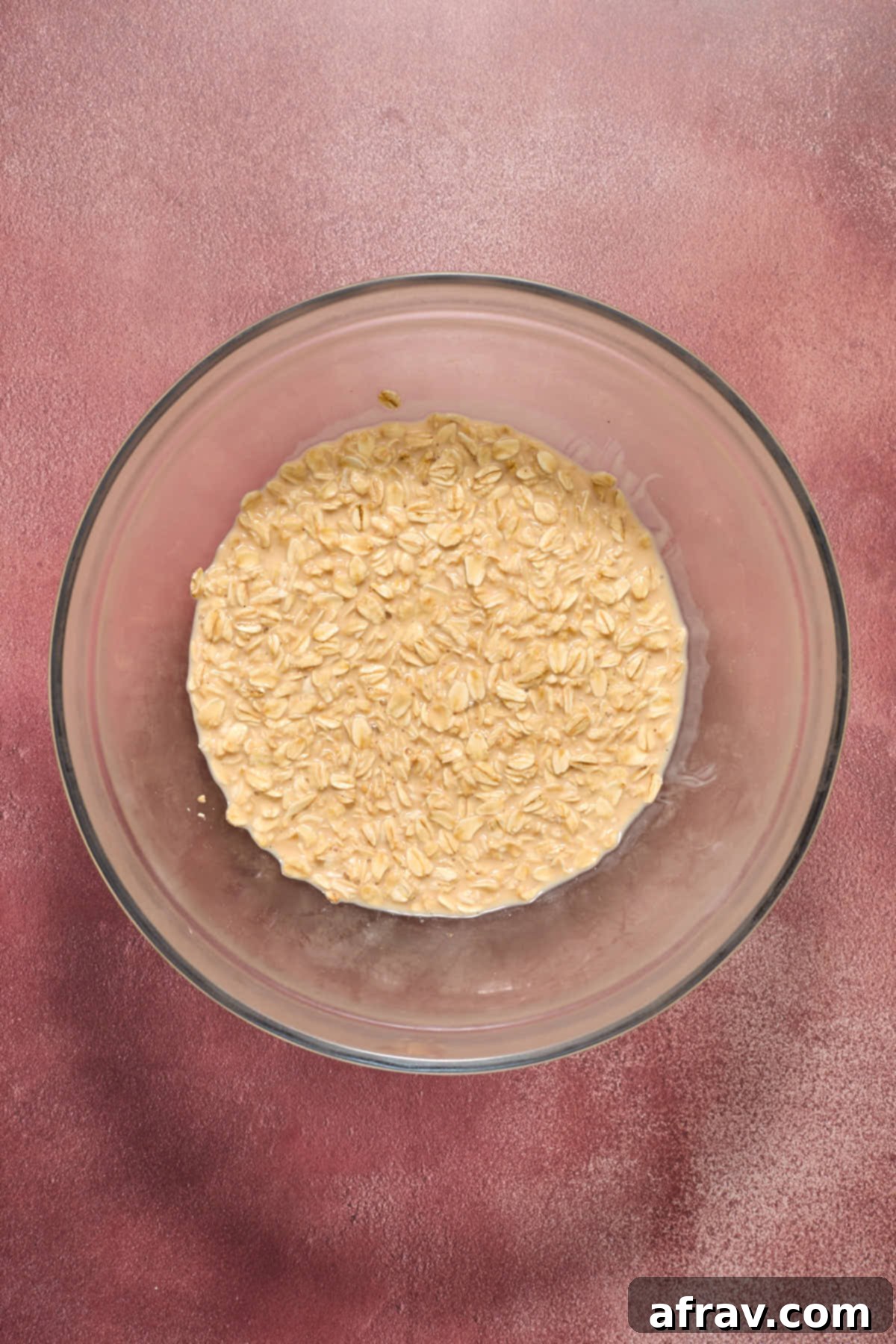 Oats soaked in eggnog in a glass bowl.