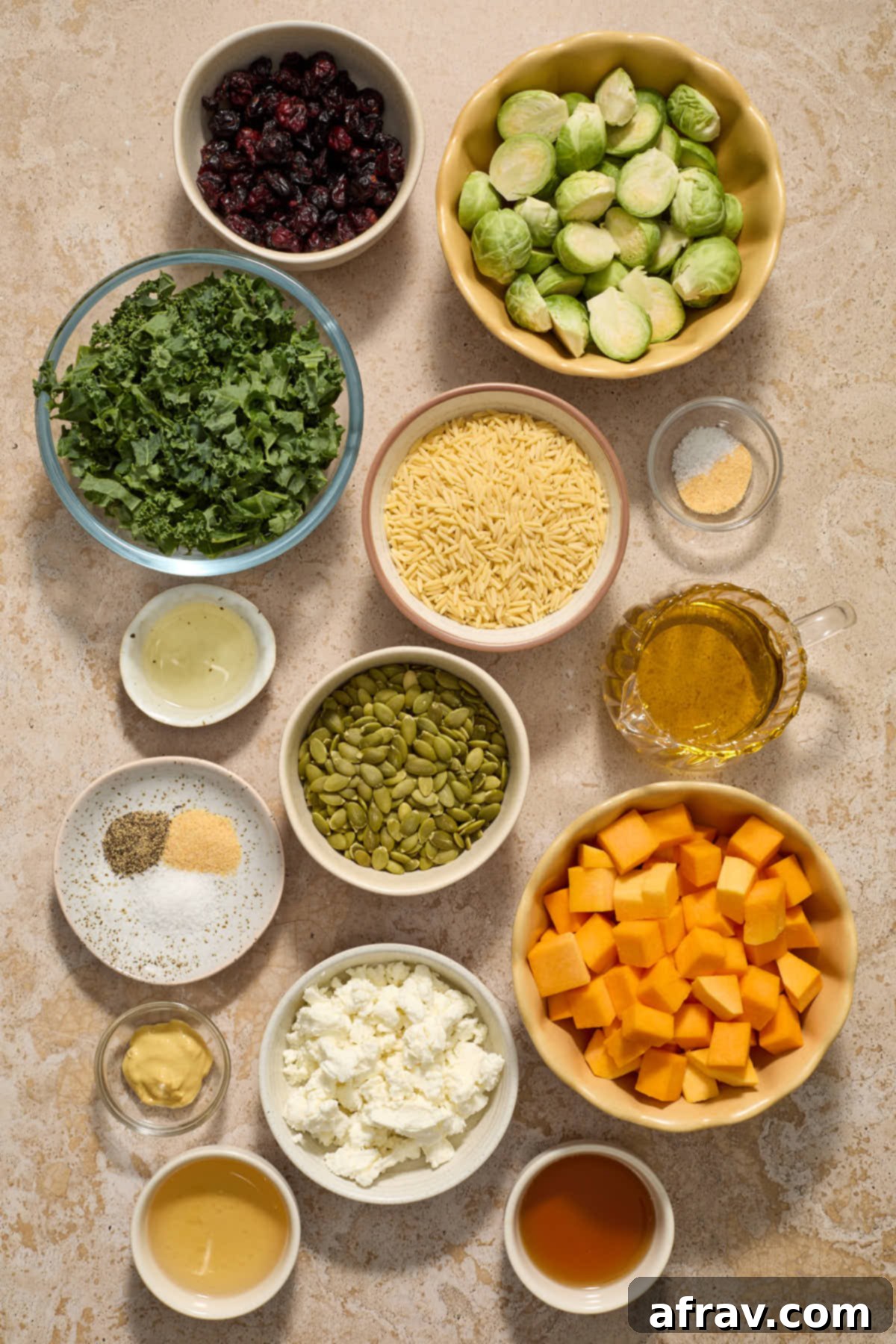 A colorful assortment of ingredients for Fall Orzo Salad arranged in individual bowls, showcasing the recipe's vibrant components.