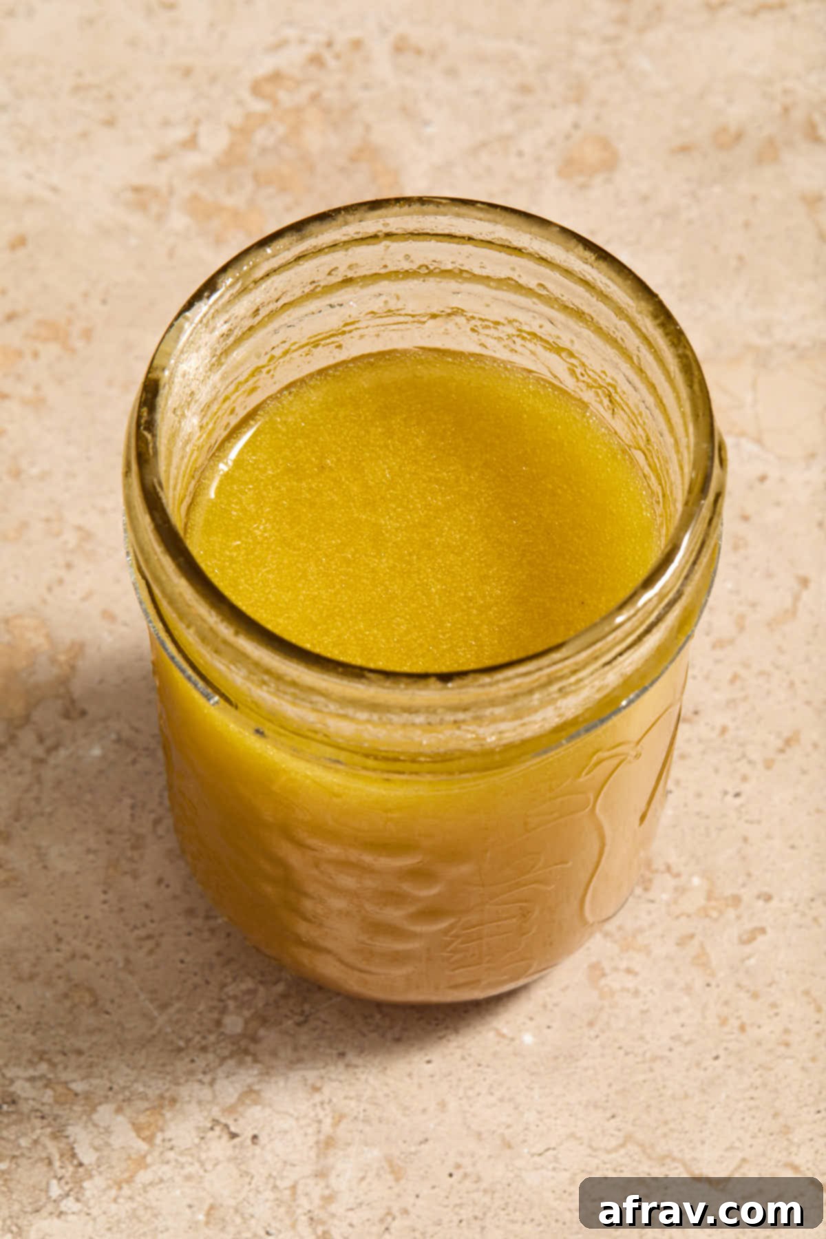 Apple cider vinaigrette ingredients mixed together in a clear glass jar.