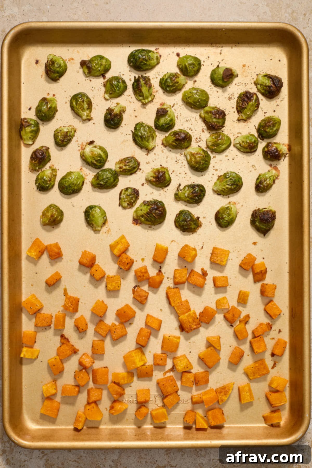 Roasted butternut squash and Brussels sprouts on a sheet pan, fresh from the oven.