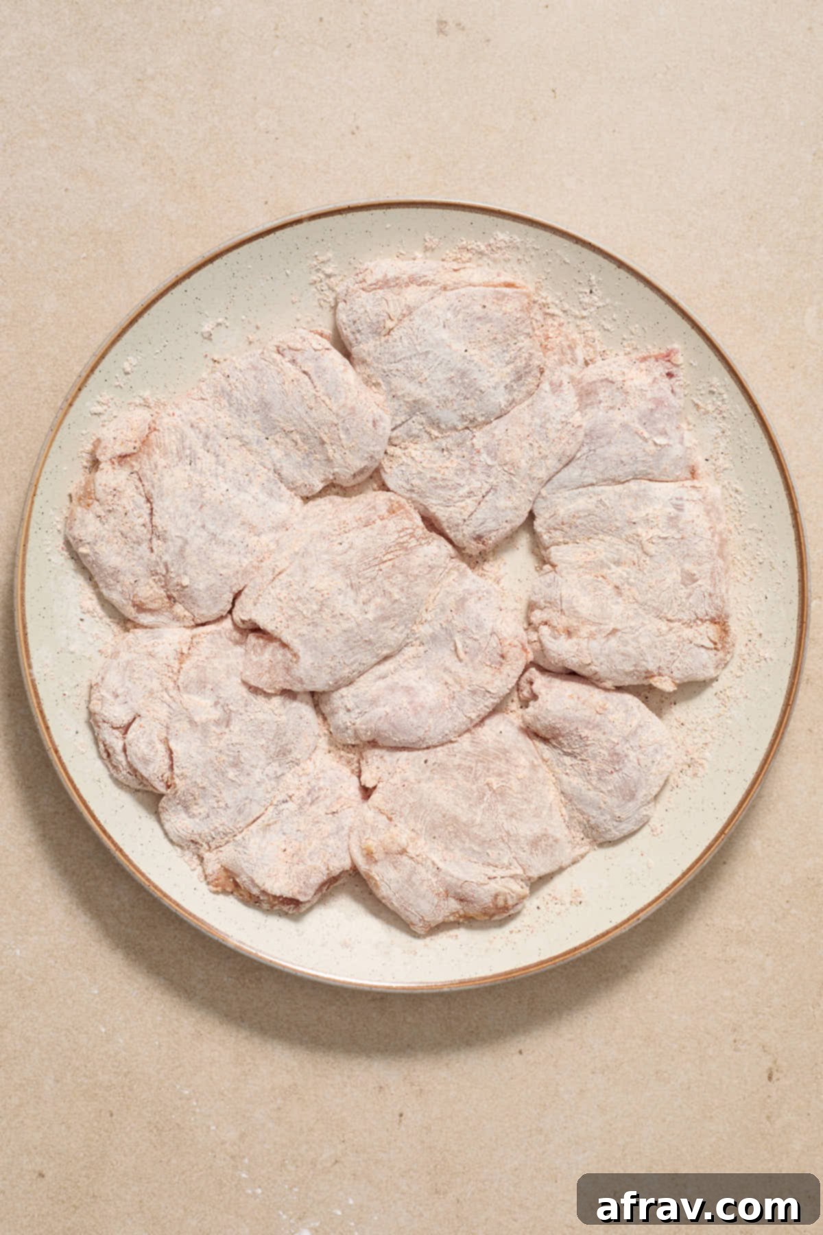 Honey Garlic Glazed Chicken Thighs: An Air Fryer Delight 4 Boneless skinless chicken thighs coated in cornstarch on a plate.