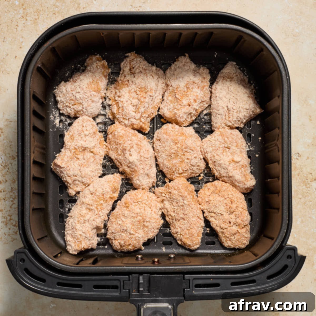 Garlic Parmesan Air Fryer Chicken Bites 11 Breaded chicken pieces arranged in a single layer in an air fryer basket.