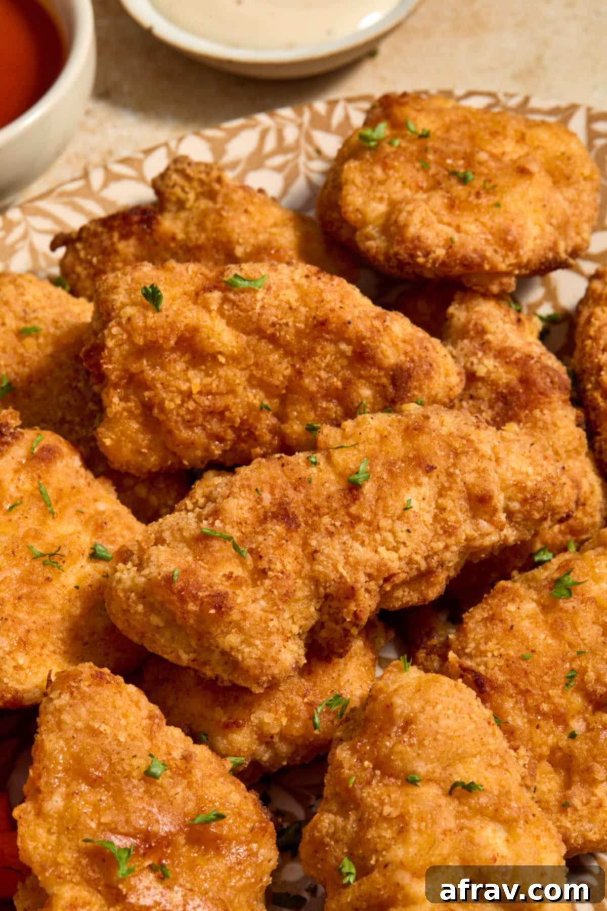 Garlic Parmesan Air Fryer Chicken Bites 14 Side view of boneless wings on a platter and garnished with chopped parsley.