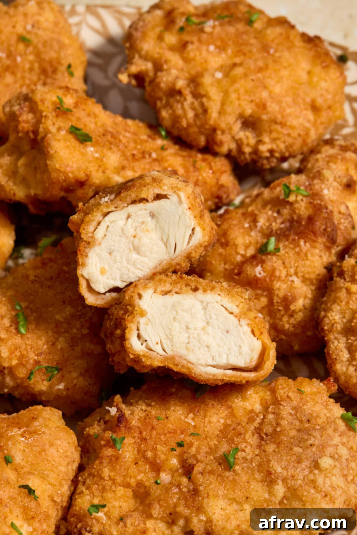 Garlic Parmesan Air Fryer Chicken Bites 15 Close up of a boneless wing cut in half to show the cooked chicken inside.