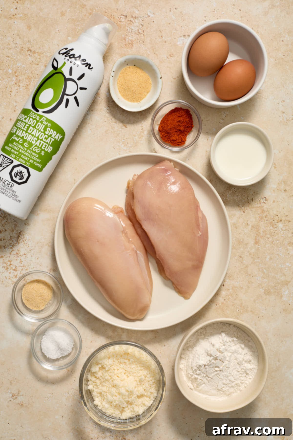 Garlic Parmesan Air Fryer Chicken Bites 3 Ingredients to make boneless chicken wings arranged individually: chicken breasts, all-purpose flour, Parmesan cheese, garlic powder, paprika, salt, onion powder, eggs, and milk.