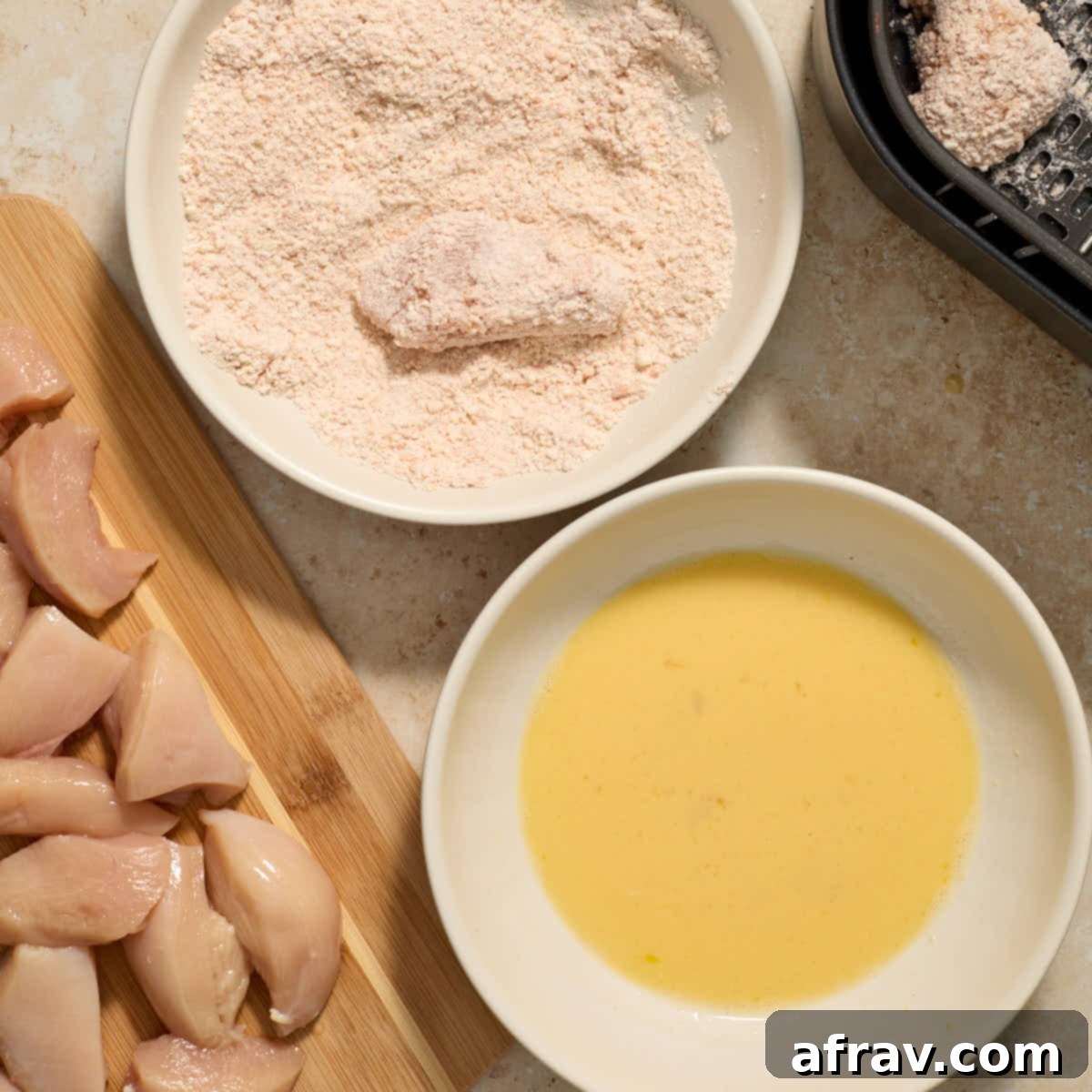 Garlic Parmesan Air Fryer Chicken Bites 8 Piece of chicken being coated in the flour mixture.
