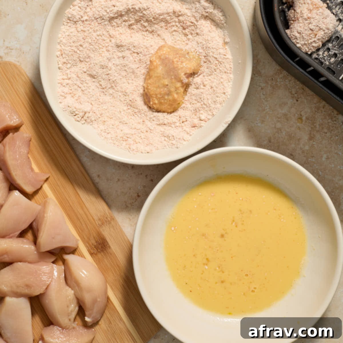 Garlic Parmesan Air Fryer Chicken Bites 10 Piece of chicken being coated in a second layer of the flour mixture.