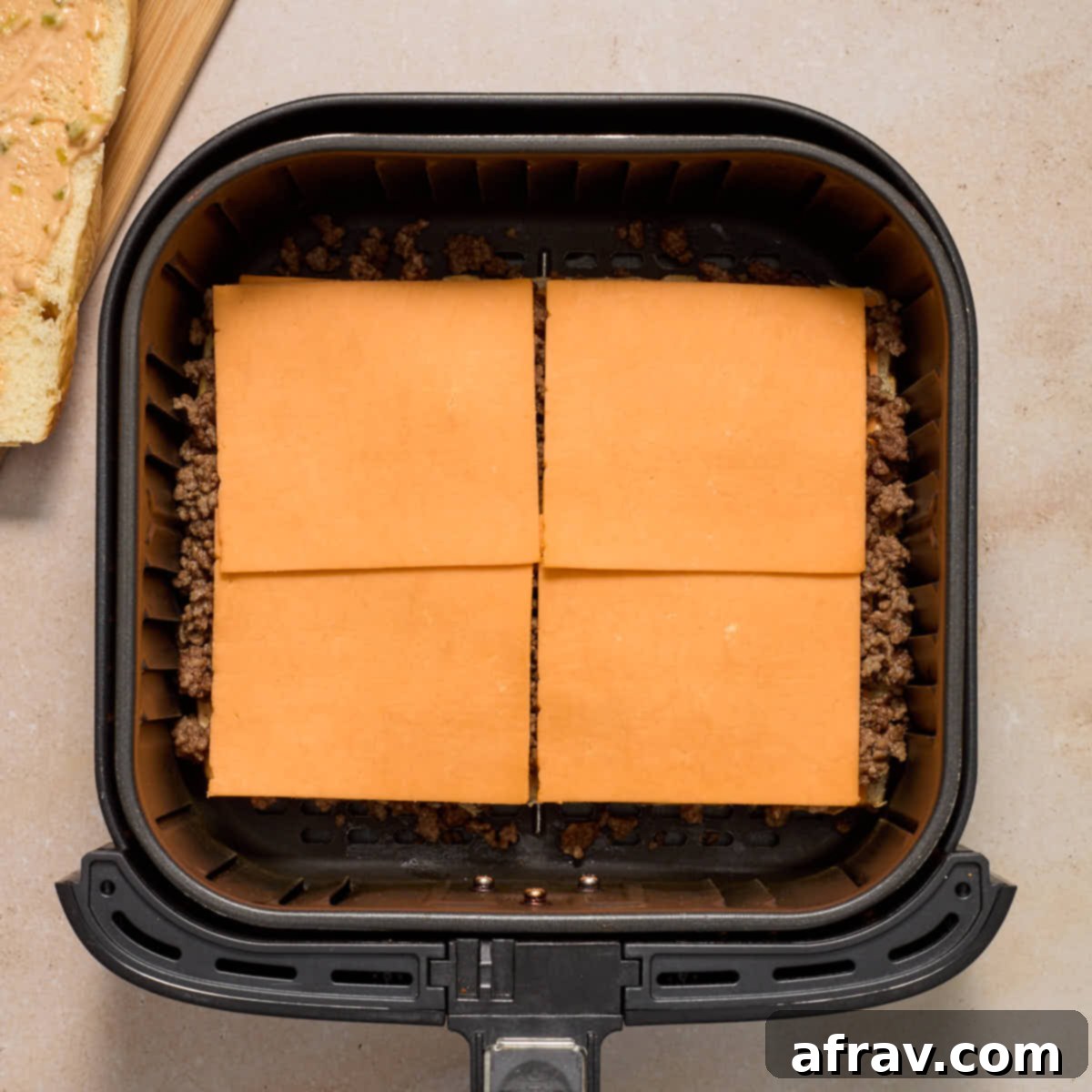 Air Fryer Mini Cheeseburgers 8 Sliced cheddar cheese, ground beef and more cheese layered on the sweet rolls in the air fryer basket.